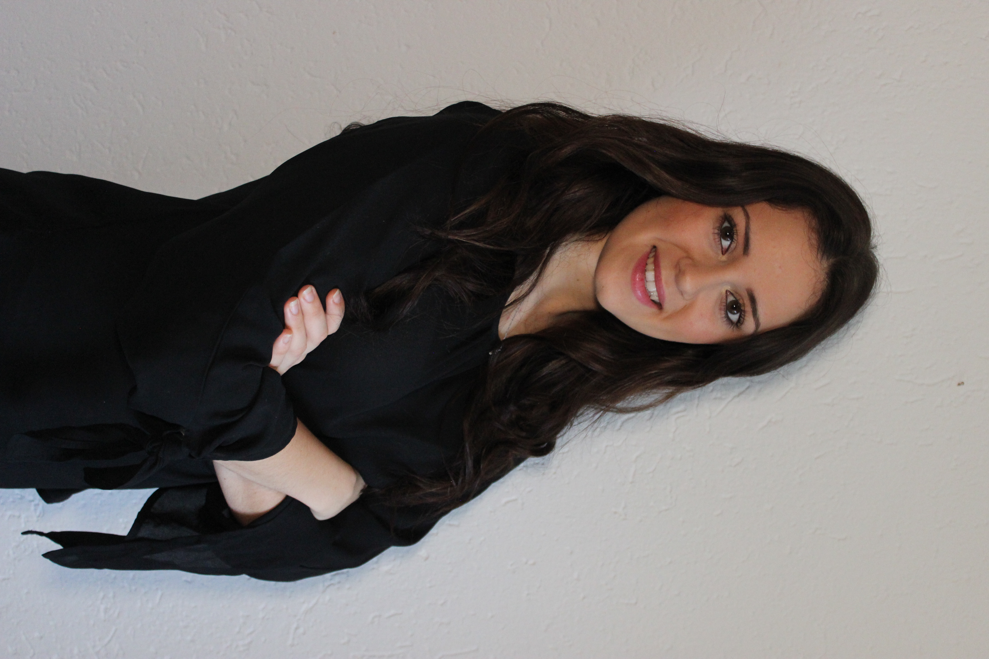 Junge FRau lehnt an der Wand.