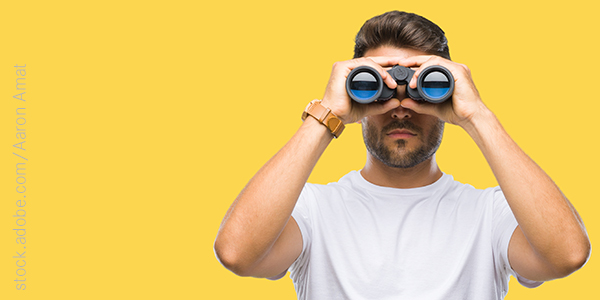 Mann mit Fernglas; Foto: adobe.stock.com/Aaron Amat
